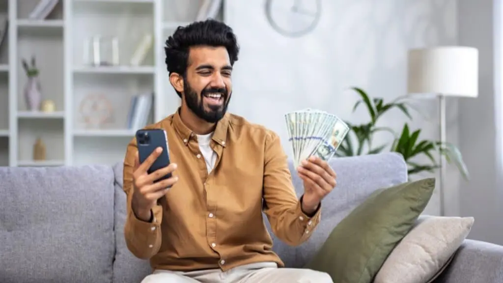 16 Ways The Rich Make Even More Money By Working Less 41 Man With Mobile And Money
