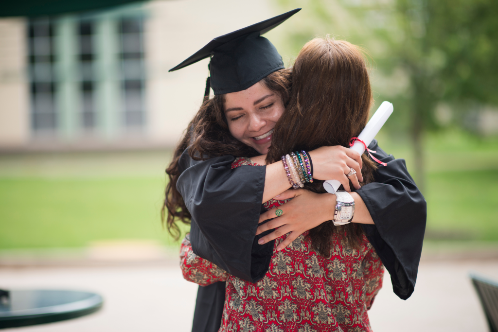 New College Graduate Hugging Family Member