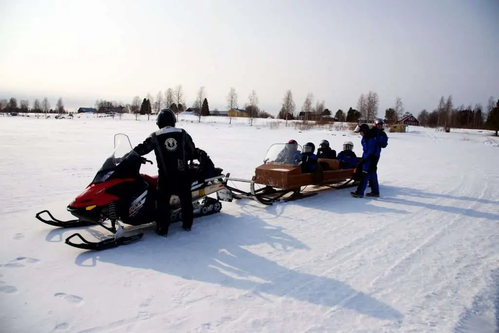 Group Snowmobiling In Lapland.