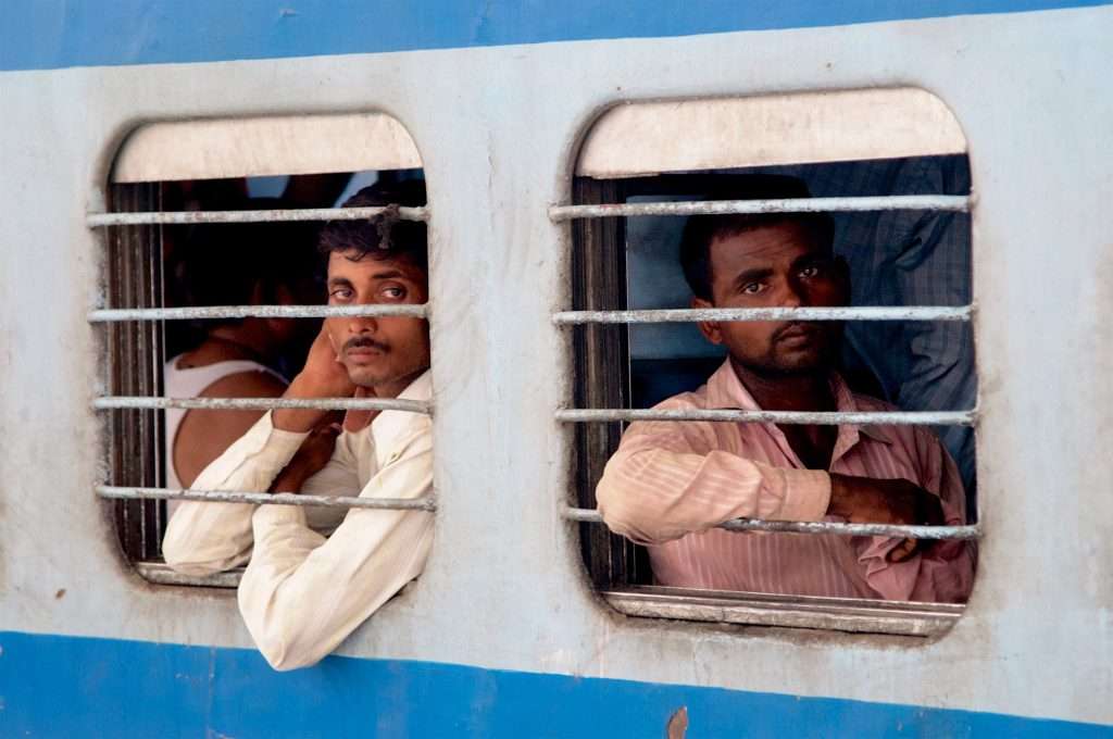 Two Men On Train At Delhi Train Station In India By Ralph Velasco