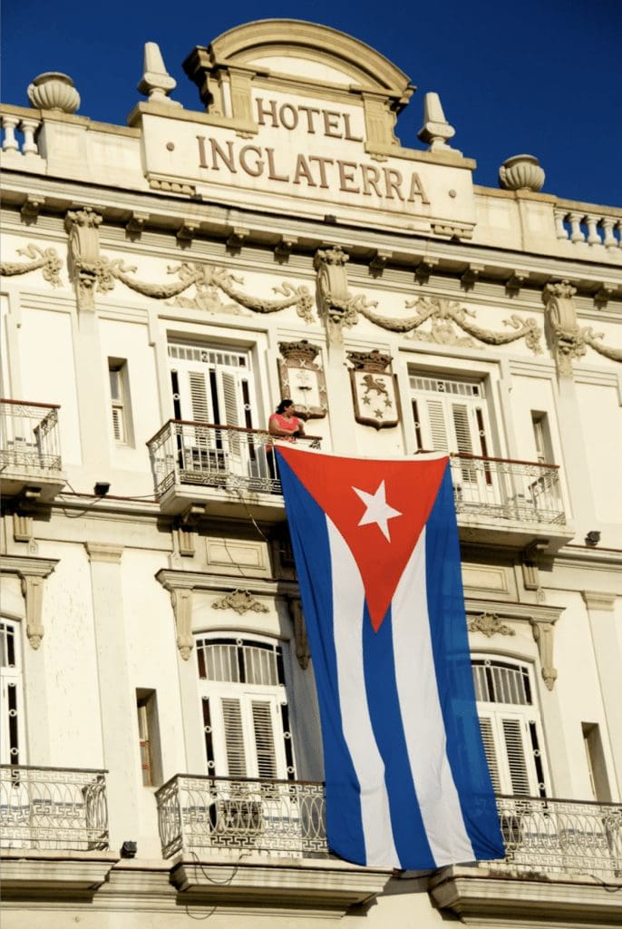 Cuban Flag Hanging From Hotel Inglaterra In Havana, Cuba By Ralph Velasco