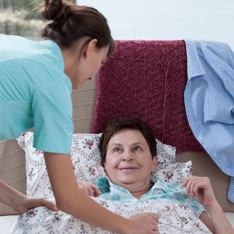 caregiver helping bedridden patient