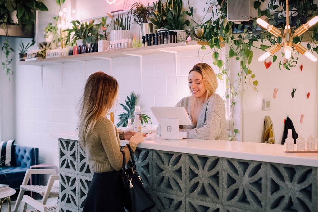 Two Beuatiful Women Over A Sales Counter Talking About A Purchase