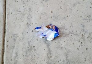 Crumbled Candy Wrapper On The Ground.