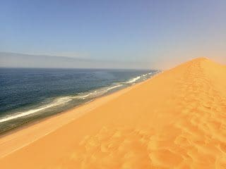 Sand Dunes Rise Up From The Beach Walvis Bay Namibia