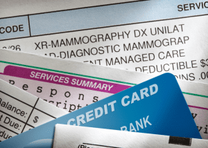 Choosing A Health Insurance Plan &Raquo; Up Close Photo Of Medical Bills With A Credit Card Tucked Between A Few Bills Canva 1 300X214 1