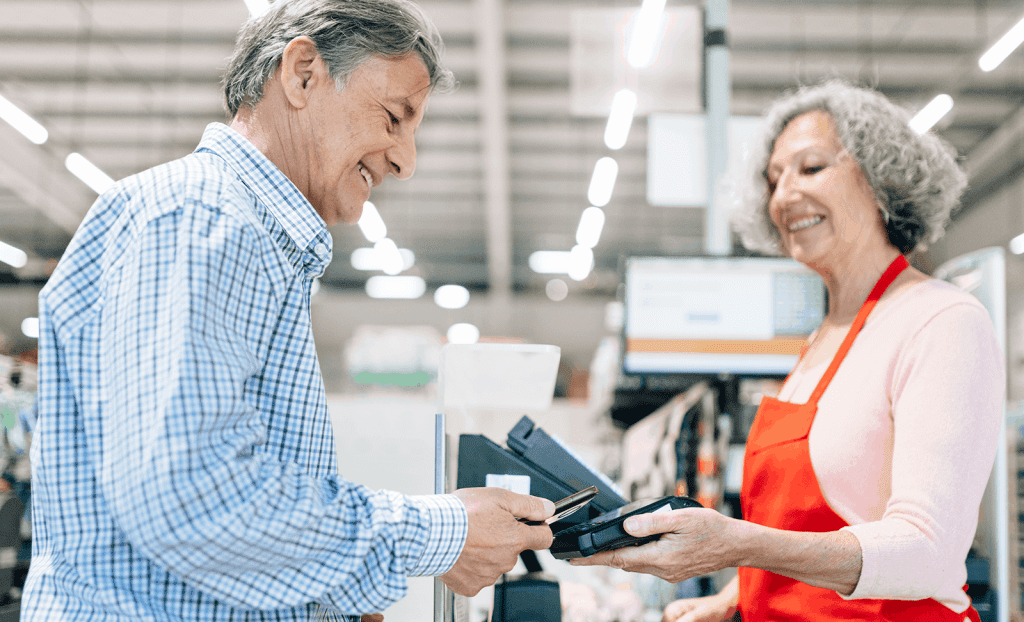 Senior Man Paying For Shopping At The Store Using His Phone