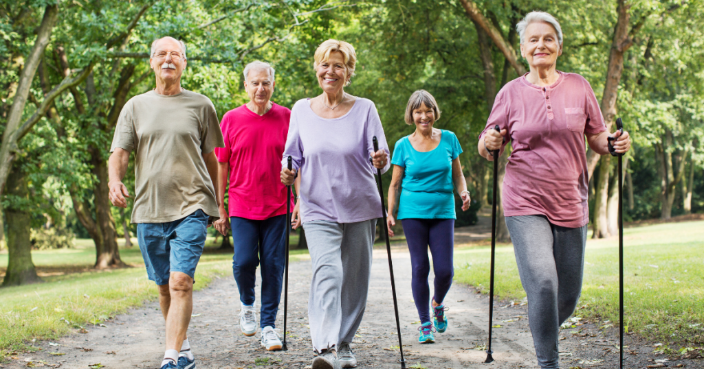 Five Seniors In Walking Group Going Through The Park