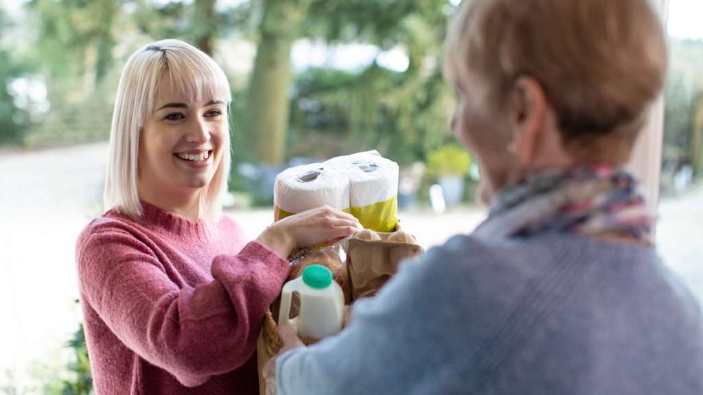 Female Neighbor Helping Senior Woman With Shopping