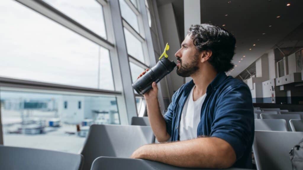 Man Siting In Airport Drinking Water