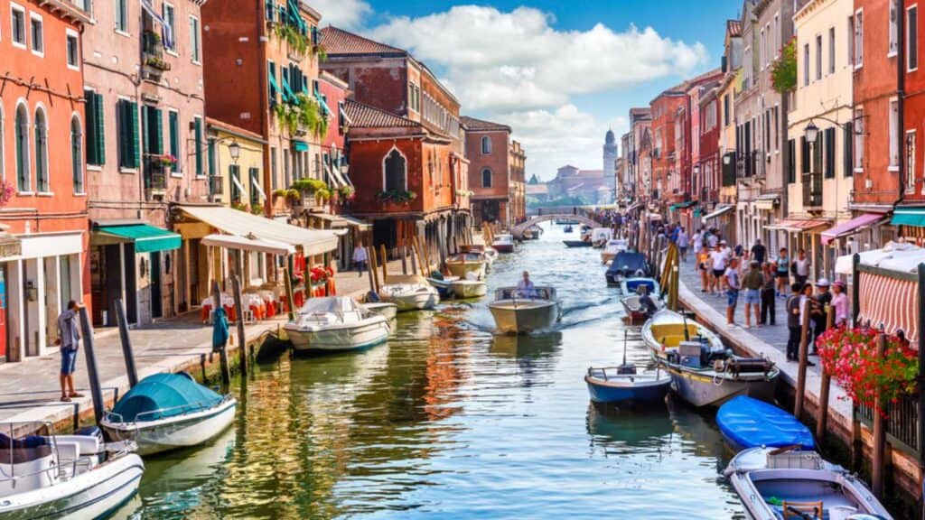 Island Murano In Venice Italy. View On Canal With Boat And Motorboat Water. Picturesque Landscape.