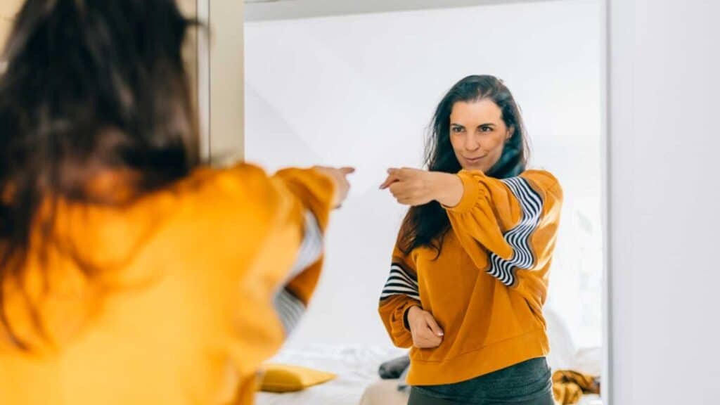 Woman Pointing Hands At Her In Mirror