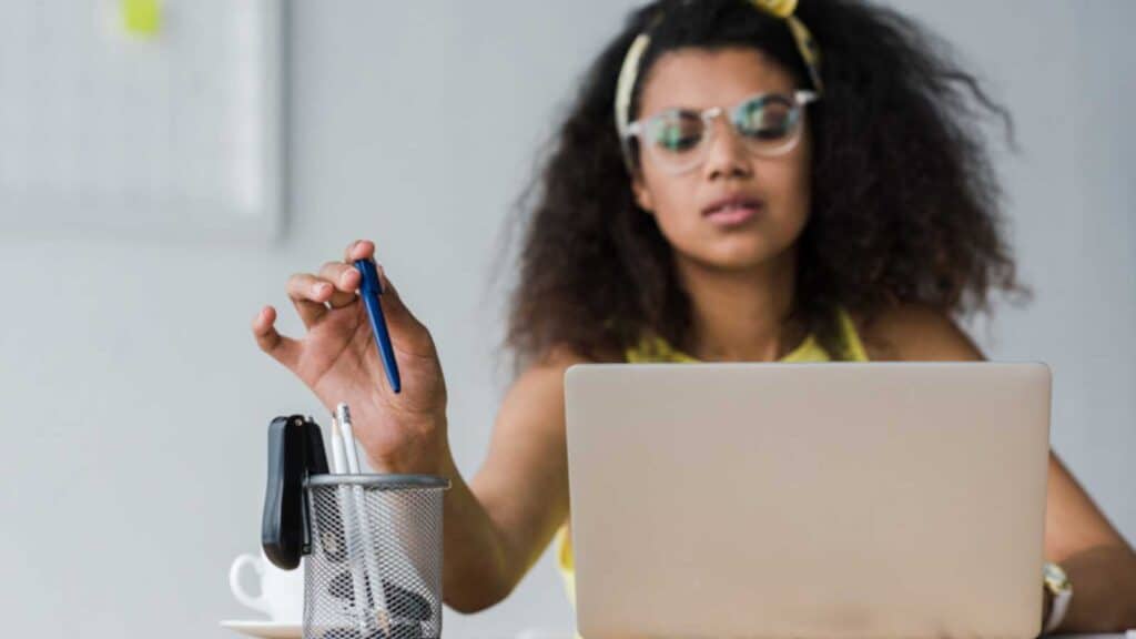 Woman Using Pens And Stapler In Office