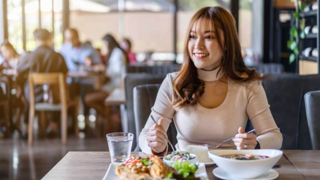 Woman Eating At Restaurant