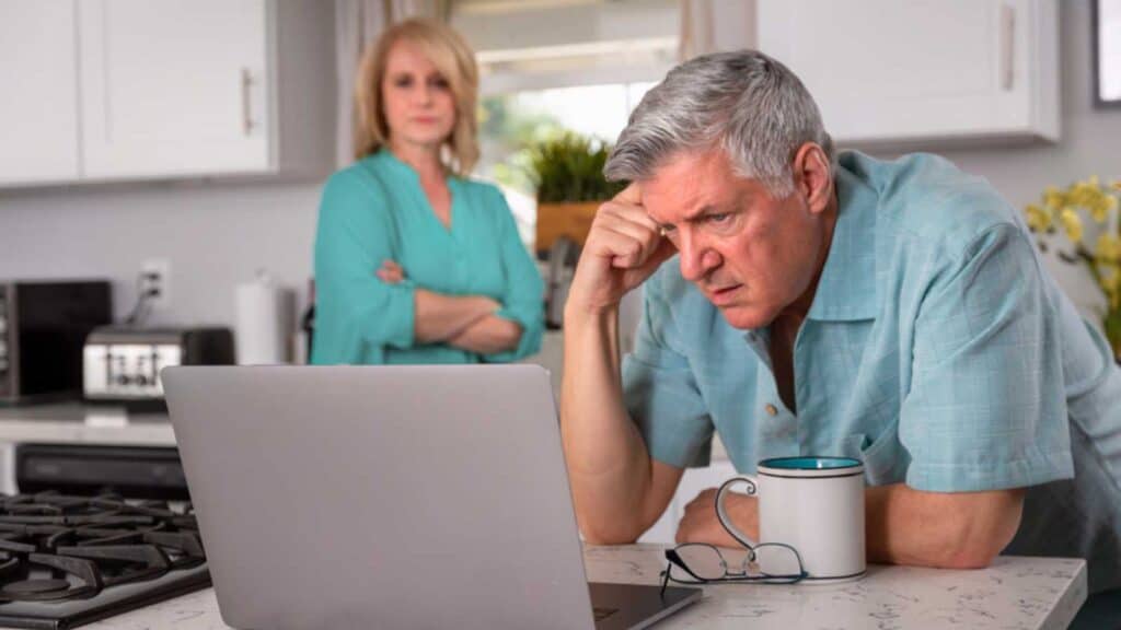 Old Man Stressed Looking At Computer Seeing Bills.