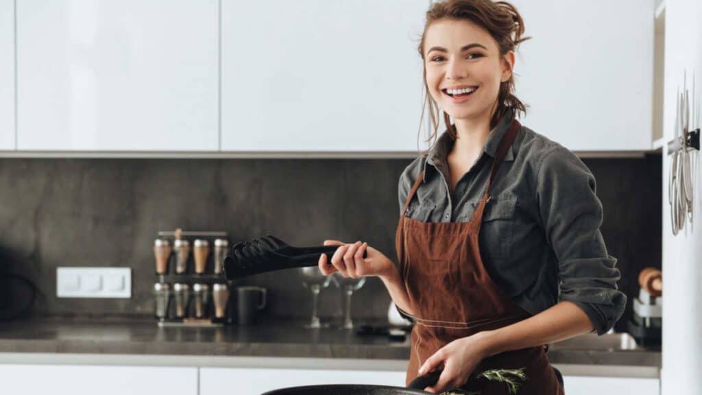 Happy Woman Cooking In Kitchen