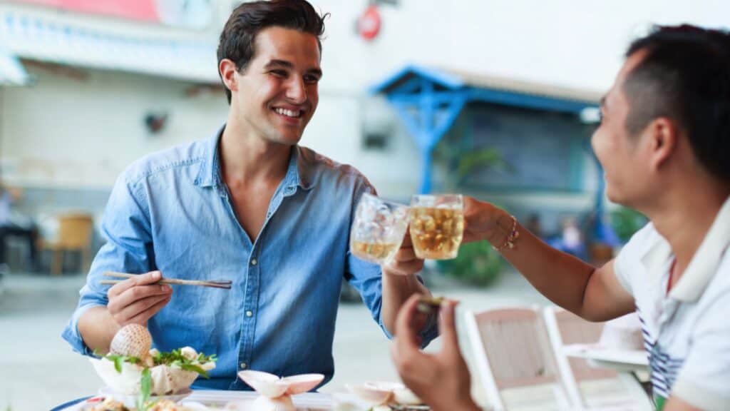 Traveler Giving Toast With Local Man