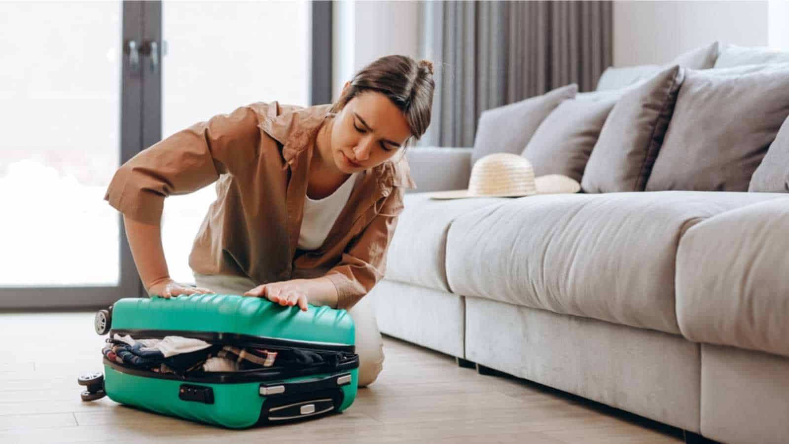 Woman Packing A Suitcase For Vacation, Travel, A Lot Of Things Do Not Fit In The Suitcase.