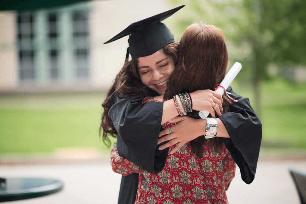 New College Graduate Hugging Family Member