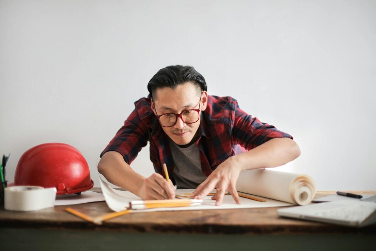 Focused Architect Drawing On Paper In Studio