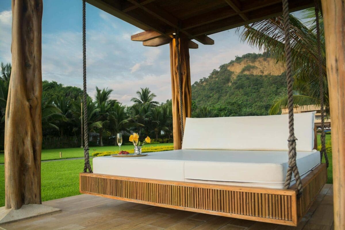 Brown Wooden Framed With White Mattress Hanging Bed Surrounded By Green Grass