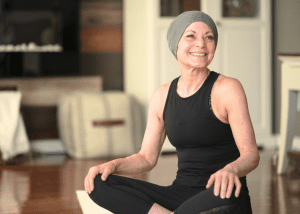 Yoga Can Help Cancer Patients &Raquo; Photo Of A Woman With Cancer Smiling While Sitting On The Floor During A Yoga Session Canva 1 300X214 1