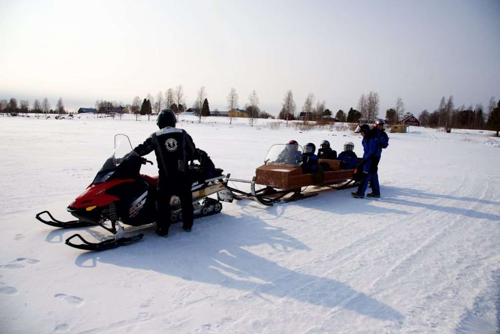 Group Snowmobiling In Lapland.