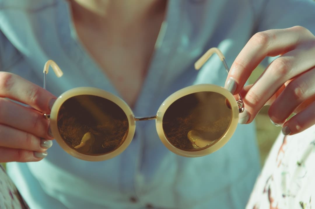 Woman Holding Round Sunglasses During Daytime