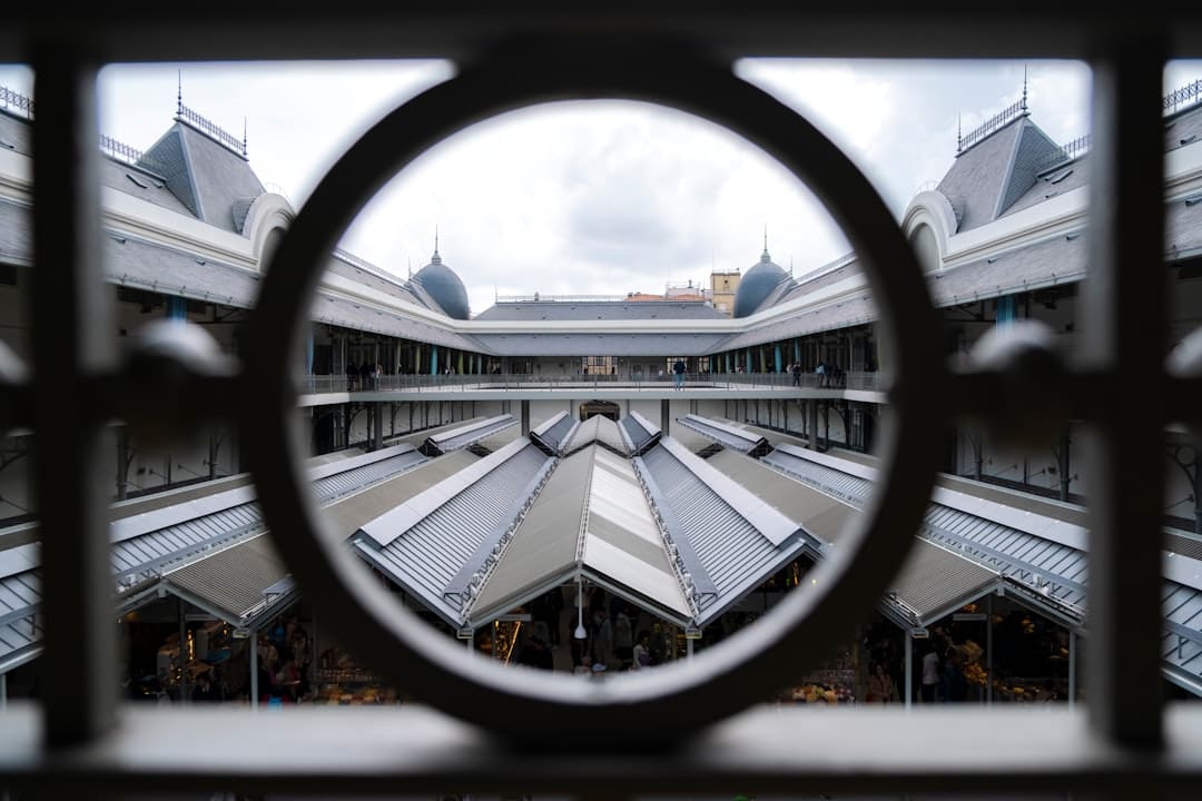 A View Of A Building Through A Circular Window