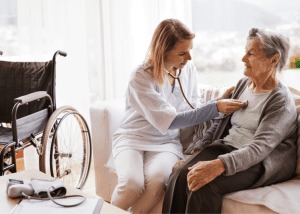 Can You Get Your Medical Care At Home? &Raquo; Photo Of A Female Doctor Checking The Heart Of A Senior Woman Sitting On A Sofa In Her Home Canva 1 300X214 1